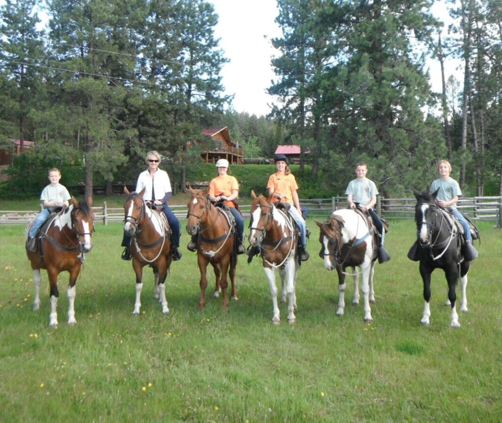 Happy riders share a smile as they pose for a horseback photo before their guided trail ride